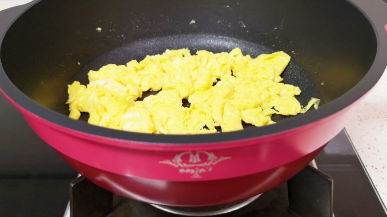 香肠炒蛋,待蛋液底部凝固以后,用铲子轻轻的推动,将鸡蛋炒熟,盛出备用。