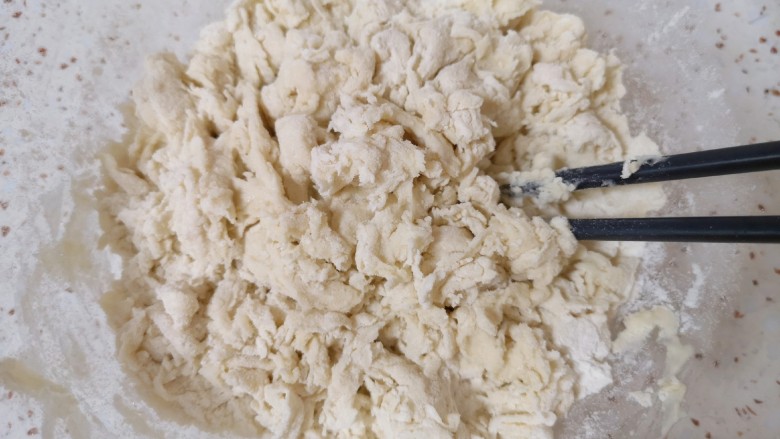 香肠馒头卷,将酵母水倒入面粉中,一边倒一边用筷子搅拌成絮状。