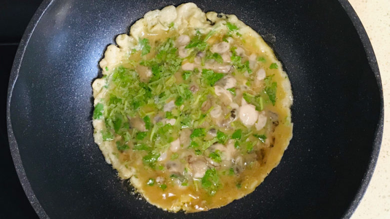 蚵仔煎,不要搅拌,转中火,煎至结实,晃动一下锅体,海蛎子鸡蛋饼可以顺利地离开锅体,就是煎结实了