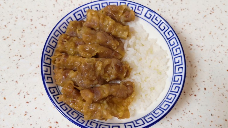 日式肥牛饭,取一个碗盛入<a style='color:red;display:inline-block;' href='/shicai/ 507'>米饭</a>,在一边摆上牛肉卷。