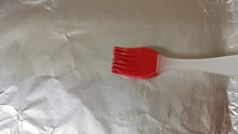 新奥尔良烤鸡腿,烤盘里铺上锡纸,刷上一层食用油。 烤箱上下管210度预热。