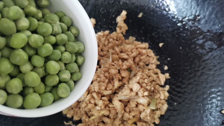 肉末炒豌豆,肉末炒至变色,倒入碗豆翻炒