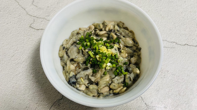 蚵仔煎,牡蛎放入碗中,加入葱花、姜末