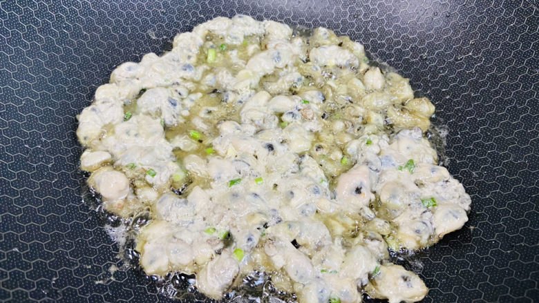蚵仔煎,用锅铲摊平,小火慢煎至表面微微透明