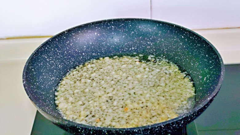 芋头蒸排骨,锅中加入食用油,油温6成热时加入蒜末小火煸炒,炒至微黄,散发香味即可关火,放旁边晾凉。