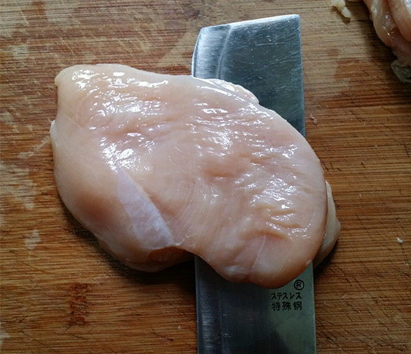 孜然鸡胸肉,鸡胸肉洗净沥干水分,用刀一片为二