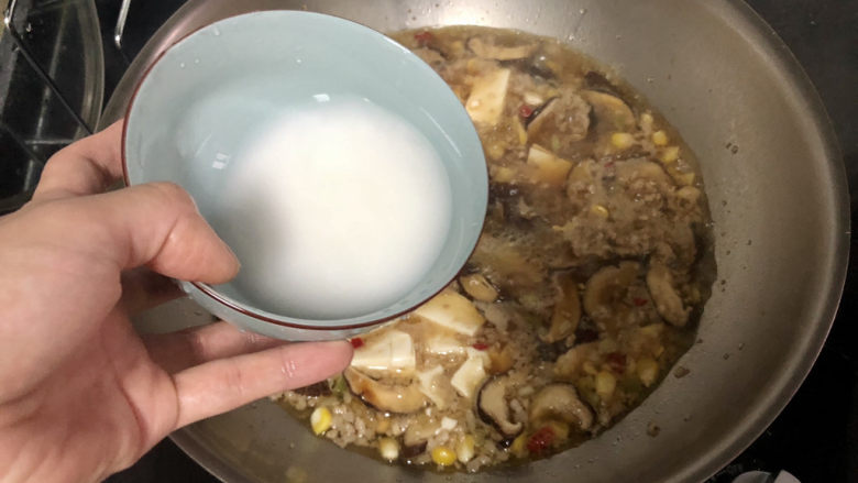香菇肉末豆腐,开盖,转中火,淋两汤匙水淀粉收汁到自己喜欢的程度,可以多留点汤汁泡饭很赞