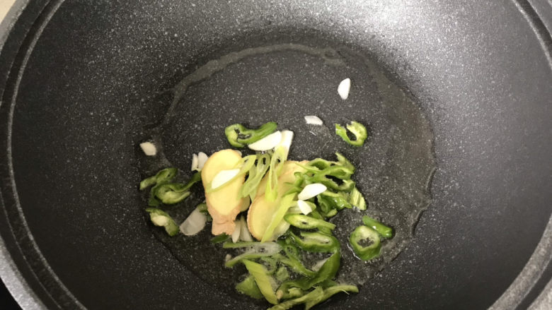 荷兰豆炒香肠,炒锅起锅烧油,下葱姜蒜和青椒炒香;