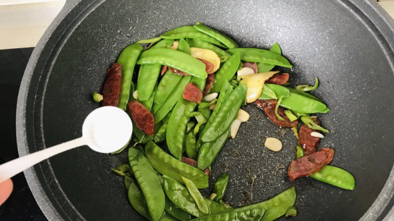 荷兰豆炒香肠,再加小半勺盐;