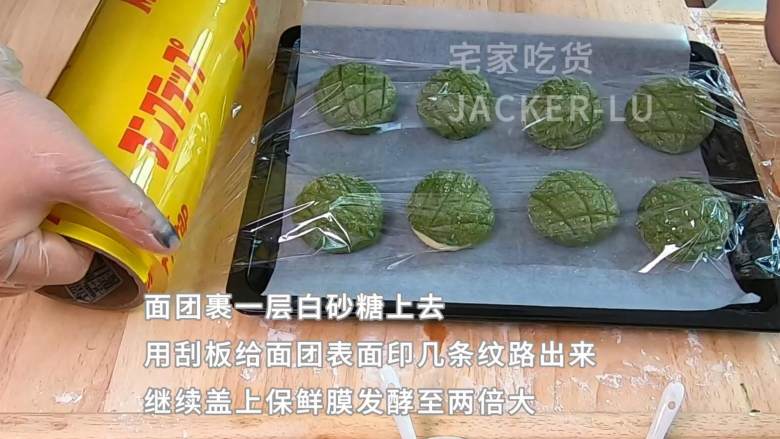 抹茶酥皮面包,表皮酥脆满满黄油味,内里软绵,一口下去满满的幸福感觉。,准备一碗白砂糖,把包好的面团再白砂糖里面滚一下,裹一层白砂糖上去,用刮板给面团表面印几条纹路出来,给表面做一下造型,继续盖上保鲜膜发酵至两倍大。