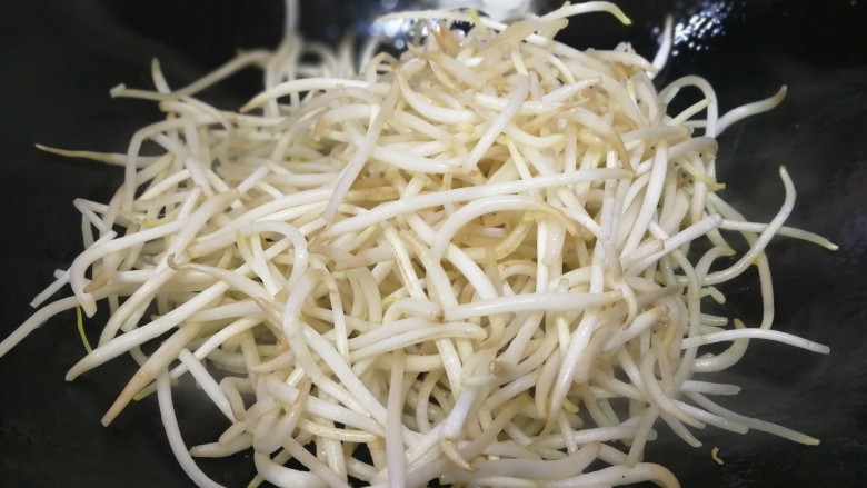 醋溜豆芽,把豆芽抓入锅内(不要倒入,盘底还会有水)