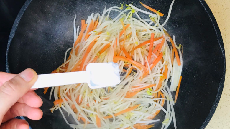 醋溜豆芽,撒上半勺盐提味,翻炒均匀就可以关火起锅了