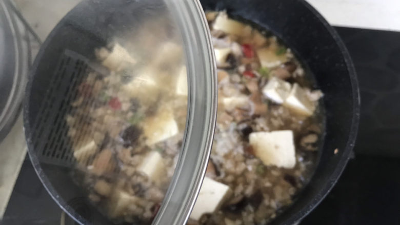 香菇肉末豆腐,让豆腐完全浸在汤汁里,盖上锅盖中小火炖10分钟左右;