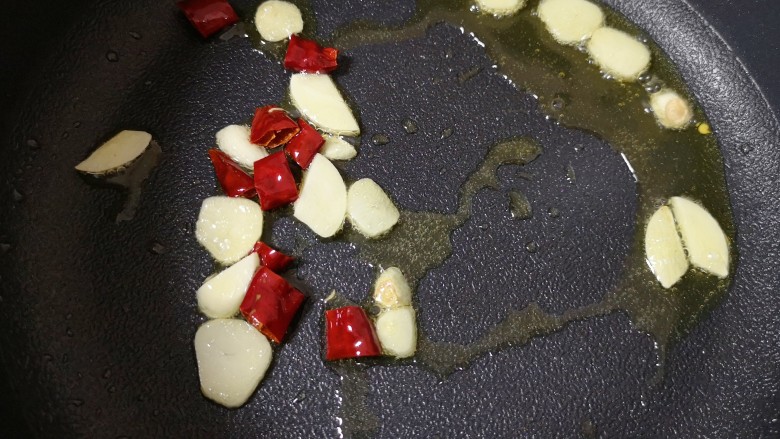 荷兰豆炒香肠,不粘锅内继续倒油烧热,下入蒜片和干红辣椒炒香。