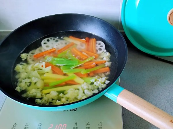简单易做的麻辣香锅,锅里放入水烧开,加一点盐一点食用油, 放莴笋和土豆以及胡萝卜条和莲藕焯水捞出备用, 放入芹菜焯水捞出备用