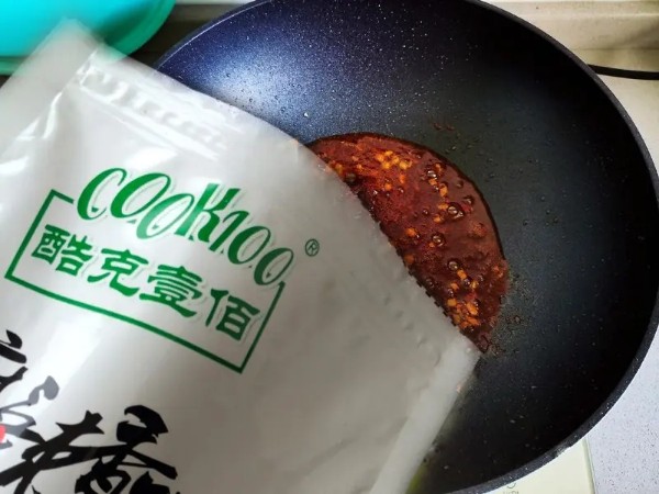 简单易做的麻辣香锅,锅里放入3勺食用油,放入蒜末炒香,倒入70克cook100麻辣香锅调料炒香