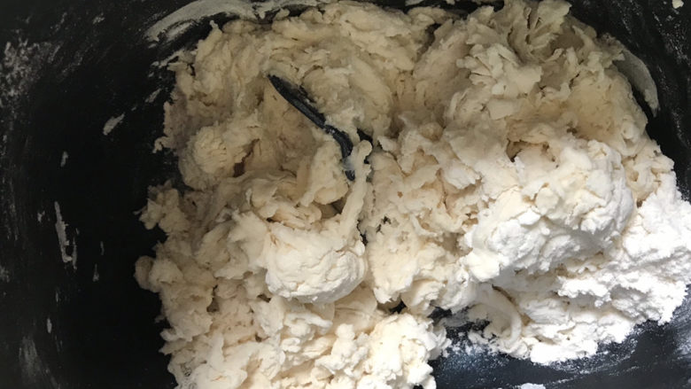 紫薯玫瑰花馒头,白色面团,称好面粉,酵母,水在面包桶里,搅拌至絮状,放入面包机启动和面程序