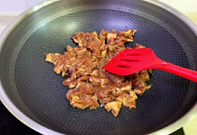 黑椒牛肉披萨,锅中倒油,烧至8成热,放入腌制好的牛肉,再加一点盐和胡椒