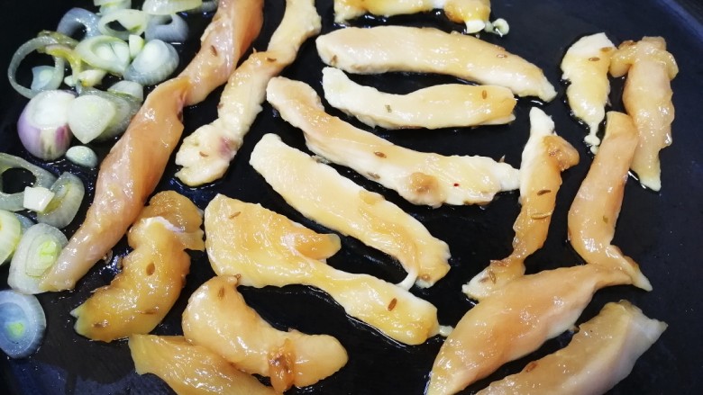 孜然鸡胸肉,把煎软的圆葱推到锅边,逐条放上鸡胸肉。