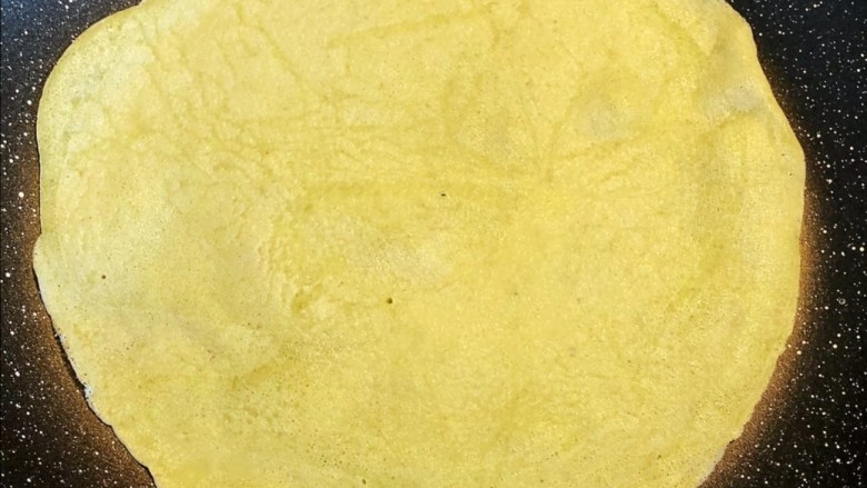锅巴菜,不粘锅加热后关火,将一勺面糊液体倒在平底锅中央,然后立刻转动平底锅,让液体均匀铺满锅底面糊成型后,再翻面