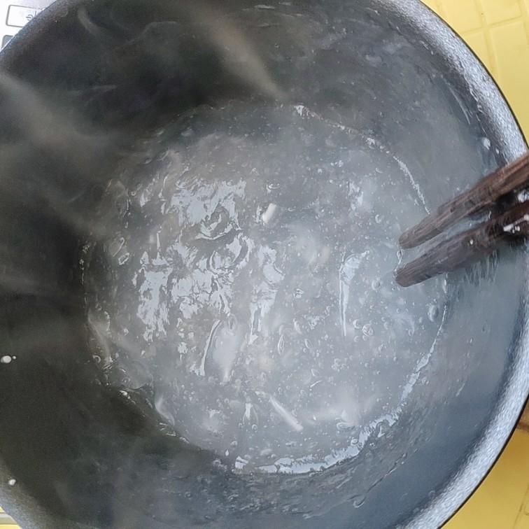 煎焖子,继续不停搅拌,搅拌到锅里颜色均匀,没有白色的絮状,就可以倒入抹好油的碗内