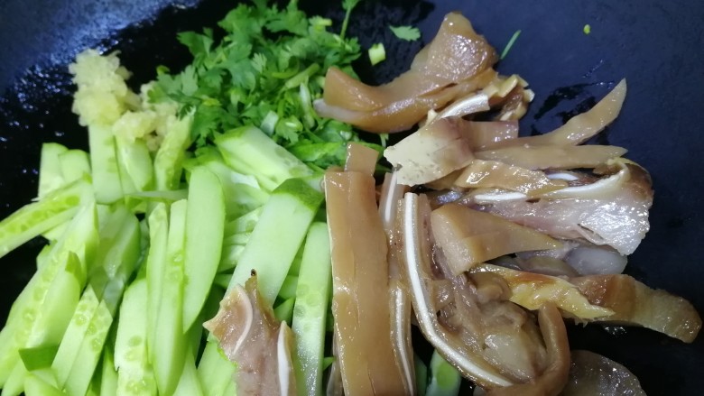 黄瓜拌猪耳朵,放入黄瓜条,切好的猪耳朵,香菜末,蒜末。