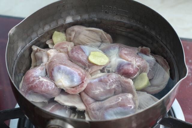 青椒炒鸡胗,将鸡胗放入水中浸泡半小时清洗干净,冷水下锅投入三片<a style='color:red;display:inline-block;' href='/shicai/ 37'>姜</a>,大火煮至沸腾后马上捞出鸡胗,晾至不烫手的状态。