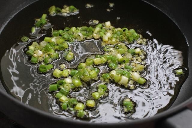 香菇炒肉片,锅中倒适量食用油烧至五成热，放入葱花和姜末小火炒出香味。