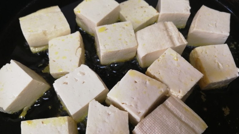 青椒炒豆腐,平底锅倒入适量油,油热放入豆腐。