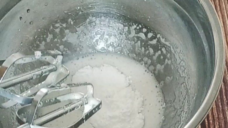 蛋白糖,等打到出现纹路后加入剩余的糖粉,继续打发。