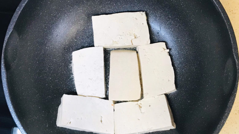 青椒炒豆腐,起油锅,油烧热后,码放进豆腐