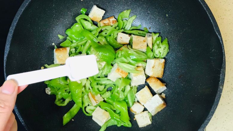 青椒炒豆腐,一直炒至青椒恹恹时,撒上盐调味