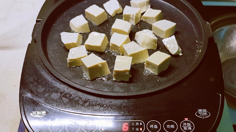 青椒炒豆腐,煎烤机放入一汤匙食用油 放入豆腐