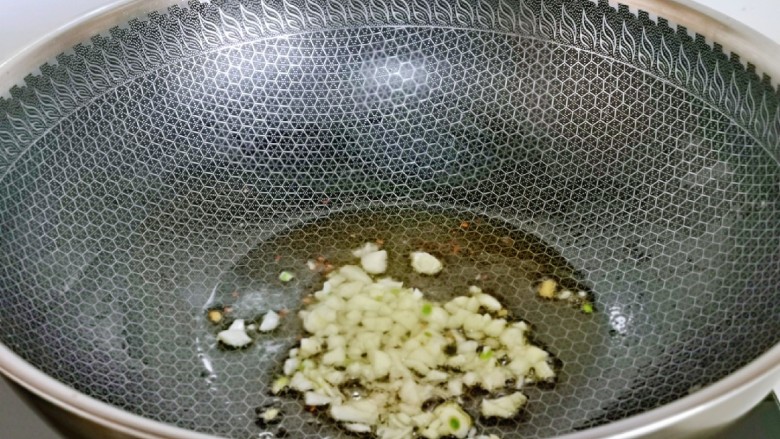 青椒炒豆腐,另起油锅,加入蒜末炒香。