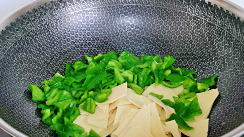 青椒炒豆腐,再加入青椒与干豆腐,翻炒均匀。
