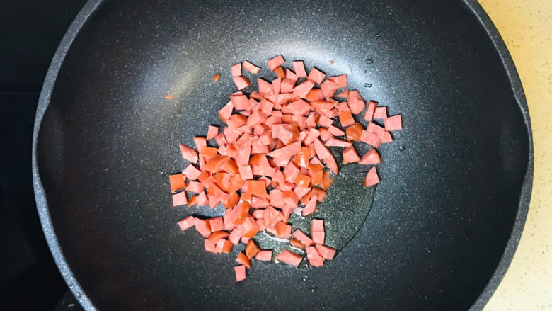 莴笋炒腊肉,冷锅热油,油烧热后,加入香肠丁翻炒