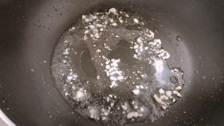 青椒炒豆腐,锅内热油,加入蒜末爆香。