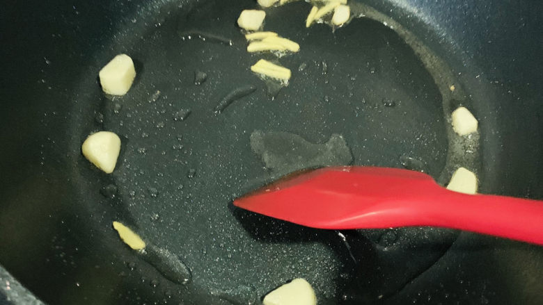 秋葵炒虾仁,锅加食用油,加蒜瓣和姜丝,炒香
