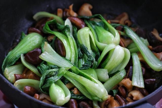 香菇炒青菜,把炒好的油菜倒入锅中与香菇混合翻炒均匀。