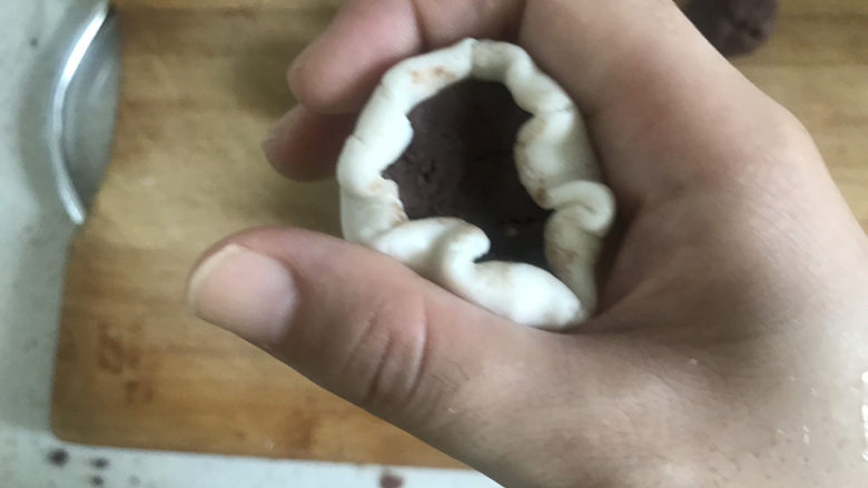 红豆糯米糍,包入一个豆沙馅,一手按住豆沙馅,另一手转动用虎口慢慢收紧,收口捏紧