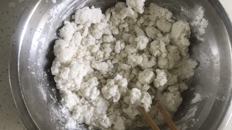 红豆糯米糍,把糖，牛奶，油都倒入糯米粉里用筷子搅拌成絮状