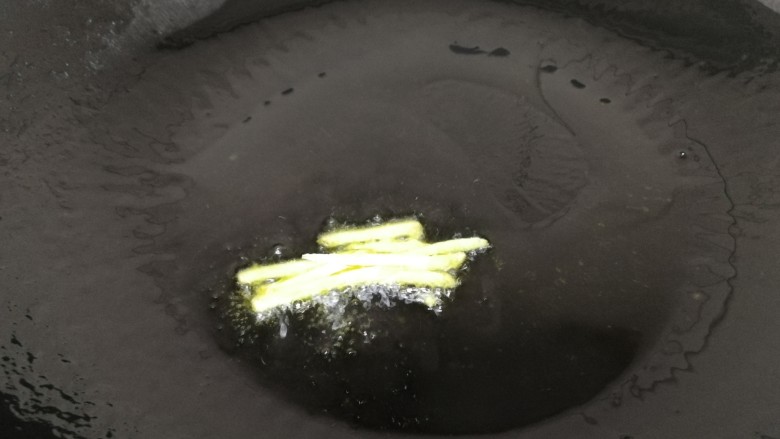 青椒炒香干,热锅倒入适量油,放入姜片小火炒香。