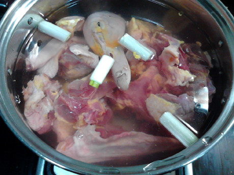 老鸭煲,将鸭肉和大葱,姜片一起放入锅中,加入清水,没过鸭肉,大火煮沸。