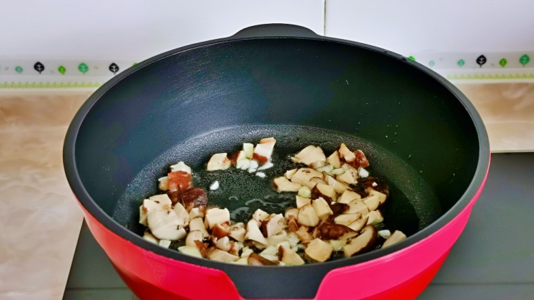 香菇炖豆腐,起油锅,加入蒜末炒香,再加入香菇煸炒。
