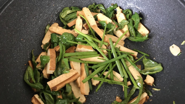 青椒炒香干,出锅前把葱绿放进去翻炒;