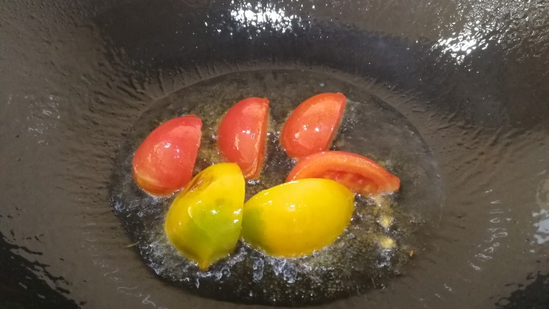 手撕包菜,热锅倒入适量油,油热放入一半的番茄,炒香。