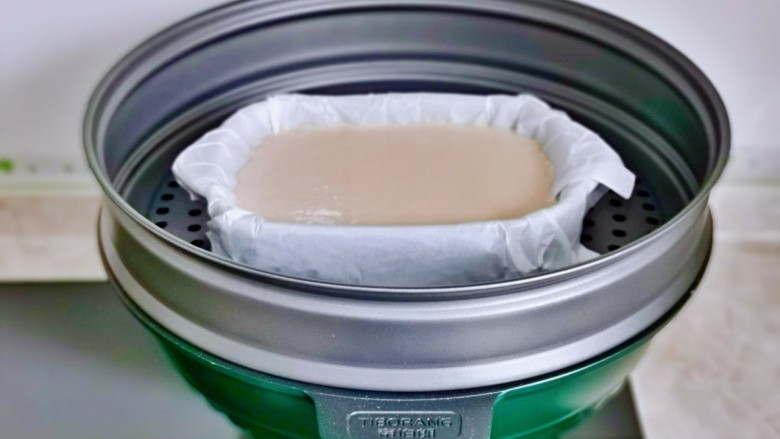 红豆糯米糍,锅中加入水,把面糊的器具放蒸屉上。