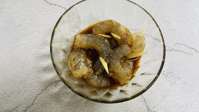 秋葵炒虾仁,将虾洗干净,剥去虾壳、虾头、挑掉虾线,放入碗中加入一勺生抽、料酒、适量白糖、胡椒粉、姜丝生粉搅拌均匀腌制十分钟