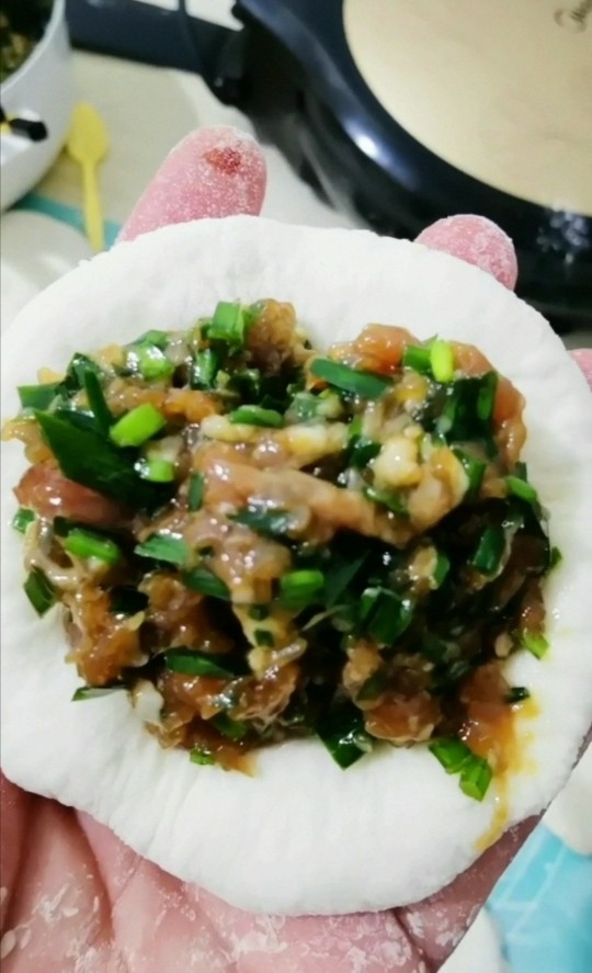 韭菜肉发面馅饼,把面团按成饼，放入肉馅