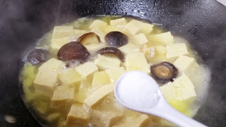 香菇炖豆腐,文火炖至10分钟,放入一小勺盐。